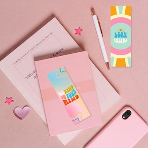 Puede incluir: Dos marcadores coloridos con mensajes inspiradores. Un marcador presenta un degradado arco&iacute;ris con el texto "Be Kind to Your Mind". El otro marcador tiene un dise&ntilde;o amarillo, rosa y azul con el texto "Look Inside".