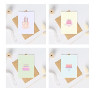 Op de afbeelding: Vier verschillende verjaardagskaarten met illustraties van taarten. De kaarten liggen op bruine enveloppen en hebben een witte achtergrond.
