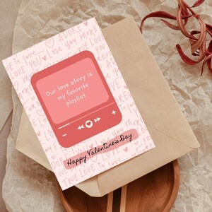 May include: A pink and white Valentine's Day card with a red music player graphic. The card says "Our love story is my favorite playlist." and "Happy Valentine's Day". The background is covered in pink hearts and the words "love", "adore", and "true love" written in pink.