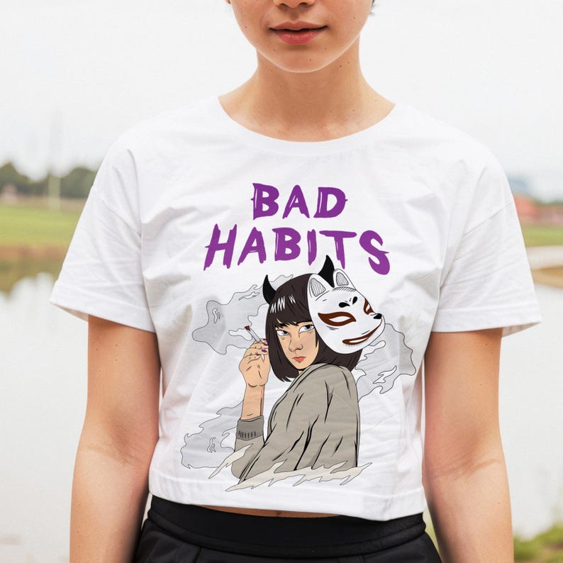 May include: White crop top with a purple graphic of a woman with a fox mask and the text "BAD HABITS".