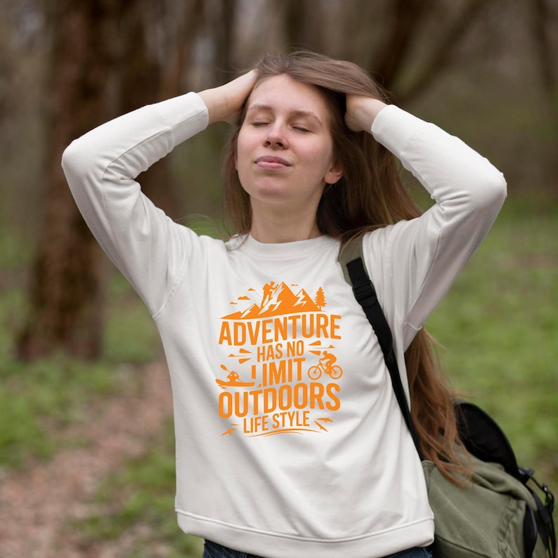 A girl wearing white hoodie showcasing adventure themed t-shirt mockup design.