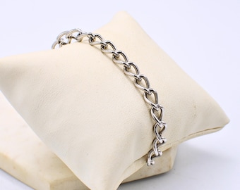 Pulseira de prata com pingente, marcada como prata de lei.