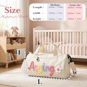 May include: Cream-colored duffel bag with the name "Asying" in colorful, textured letters and a white flower accent. The bag has a top handle and a detachable shoulder strap. Medium size: 13.0 inches long, 7.1 inches wide, and 7.1 inches high.