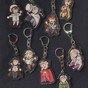 Peut inclure: Dix porte-clés colorés représentant des personnages d'anime. Chaque porte-clés est en acrylique transparent avec une image colorée d'un personnage. Les porte-clés sont attachés à des anneaux de clés en métal argenté.