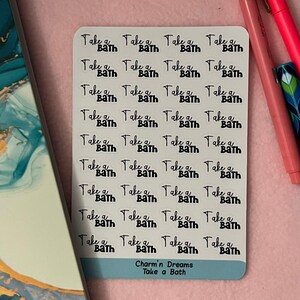 May include: A sheet of white stickers with the phrase "Take a Bath" repeated 20 times in black text. The bottom of the sheet says "Charm'n Dreams Take a Bath".