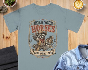 Maglietta Hold Your Horses con grafica di un procione impertinente e cowboy, maglietta western divertente in stile vintage, regalo per gli appassionati di musica country.