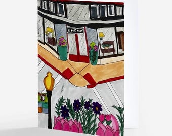 May include: A greeting card featuring a colorful marker illustration of a street corner shop with large windows, red doors, and potted plants. A yellow street lamp stands in the foreground near a garden bed filled with purple and pink flowers.