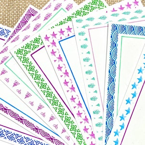 Könnte beinhalten: Ein Set mit 12 leeren Karten mit verschiedenen dekorativen Rändern. Die Ränder zeigen verschiedene Muster, darunter Sterne, Bäume und geometrische Designs. Die Karten sind weiß mit einer dezenten Textur und eignen sich perfekt zum Schreiben von Notizen oder Nachrichten.