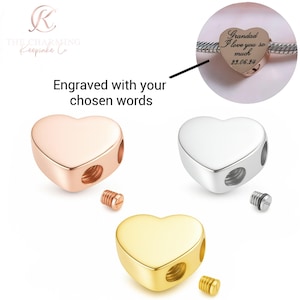 Può includere: Ciondoli a forma di cuore in oro rosa, argento e oro. Ogni ciondolo ha due fori e una vite. L'immagine include un primo piano di un ciondolo inciso con le parole "Grandad I love you so much 23.06.24". Il testo sull'immagine dice "Incisione con le tue parole scelte".