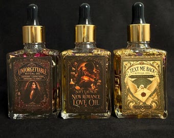 May include: Three square glass bottles with gold dropper caps containing ritual oil. The labels read Unforgettable Ritual Oil, Soft Launch New Romance Love Oil, and Text Me Back Ritual Oil. Each bottle contains visible dried botanical elements.