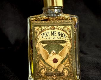 May include: A rectangular glass bottle filled with yellow oil and dried herbs, featuring a gold dropper cap. The label displays the text "TEXT ME BACK RITUAL OIL COMMUNICATION OIL WITCH ELIXIR" with an illustration of a white dove carrying an envelope.