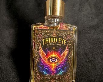 May include: A rectangular glass bottle with a gold dropper cap containing a yellow liquid and dried flower petals. The label features a colorful graphic of a winged eye with the text "THIRD EYE RITUAL OIL" and "AWAKEN SEE TRANSFORM WITCH ELIXIR".