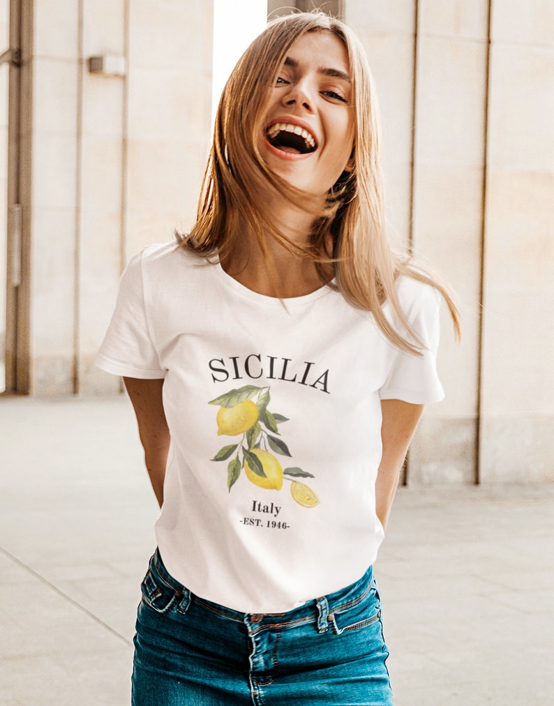 May include: White t-shirt with a graphic of lemons and the text "SICILIA Italy -EST. 1946-"