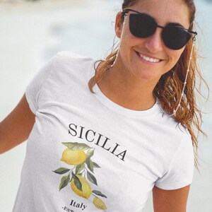 May include: White t-shirt with a lemon tree graphic and the text "SICILIA Italy -EST. 1946- "