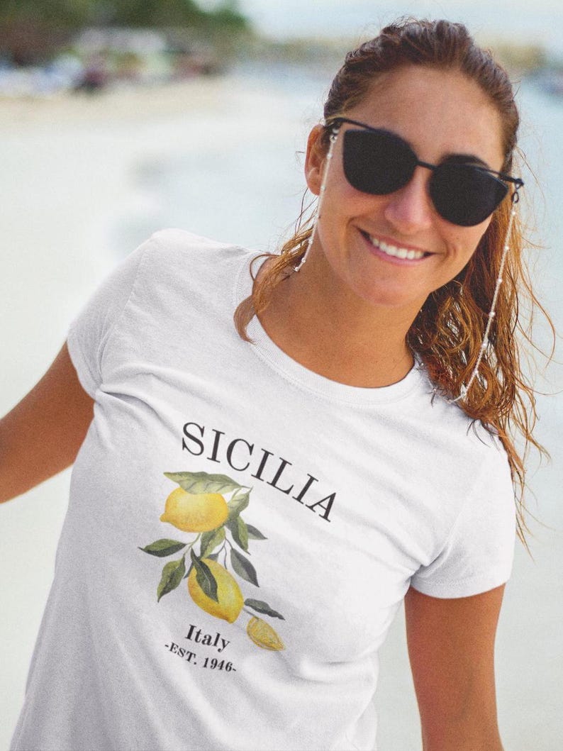 May include: White t-shirt with a lemon tree graphic and the text "SICILIA Italy -EST. 1946- "