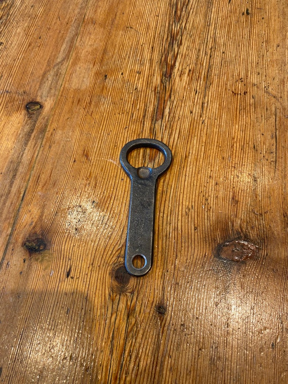A blacksmith actually hammered this bottle opener into existence — the hammer marks, imperfections, and raw iron finish make every piece one-of-a-kind in a way no factory ever could.