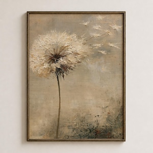 May include: A framed oil painting on canvas depicting a single dandelion with a textured, cream-colored seed head. The seeds appear to be blowing away toward the right side of the frame against a muted, neutral-toned background with earthy green tones.
