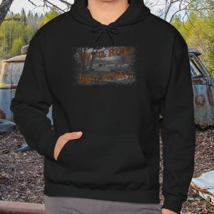 Op de afbeelding: Zwart hoodie met een grafische print van een roestig voertuig en de tekst "Until Rust Do Us Part".