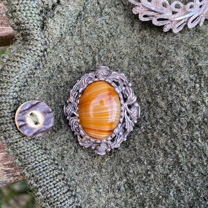 Celtic style brooch with tiger&#39;s eye in a decorative setting of unmarked silver.