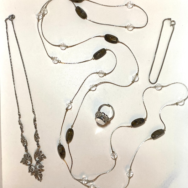 Parure comprenant deux colliers, une petite chaîne et une bague réglable avec cabochon en verre gris fumé