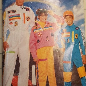 May include: Butterick 5133 sewing pattern featuring three people in racing-themed outfits. The outfits include white, pink, and blue jumpsuits with patches, stripes, and the number "1". The pattern is for size A.