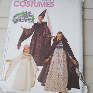 May include: A sewing pattern for three costumes: a purple hooded gown, a white gown with a gold trim, and a purple hooded cloak with a floral print dress. The pattern is from McCall's Costumes and is titled "Zoo Terz".