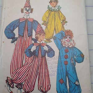 May include: A Simplicity 9051 sewing pattern envelope for clown costumes in sizes 2-4. The illustration features three variations of clown outfits, including a blue jacket with red and white striped pants, a yellow jumpsuit, and a blue jumpsuit.
