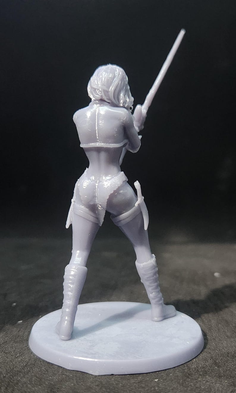 May include: A 3D printed figurine of a female figure holding a sword. The figure is wearing a detailed outfit with a skirt and boots. The figurine is painted in a light gray color.