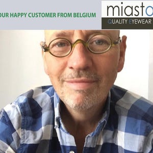 Peut inclure: Un homme portant une chemise à carreaux bleus et blancs et des lunettes rondes à monture verte. Le texte "miasto QUALITY EYEWEAR" est visible dans le coin supérieur droit de l'image.