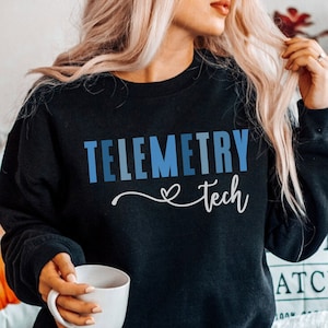May include: A black sweatshirt with the text "Telemetry tech" in blue and white lettering with a heart symbol.