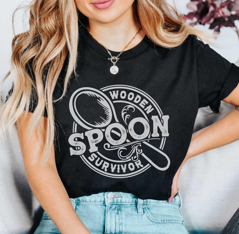 May include: A black t-shirt with a white graphic design of a wooden spoon with the text "Wooden Spoon Survivor".