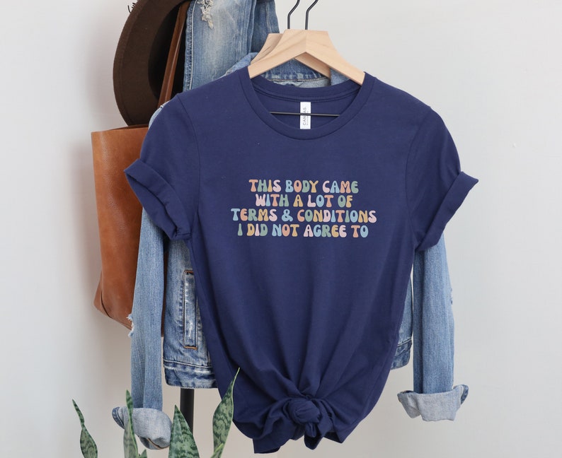 May include: Navy blue t-shirt with a colorful graphic that reads "This body came with a lot of terms & conditions I did not agree to".