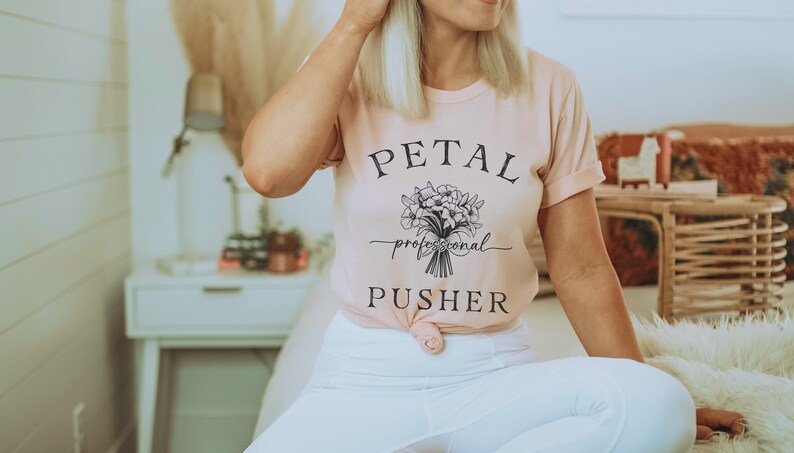 May include: A pink t-shirt with the text "PETAL professional PUSHER" and a black and white illustration of a bouquet of flowers.