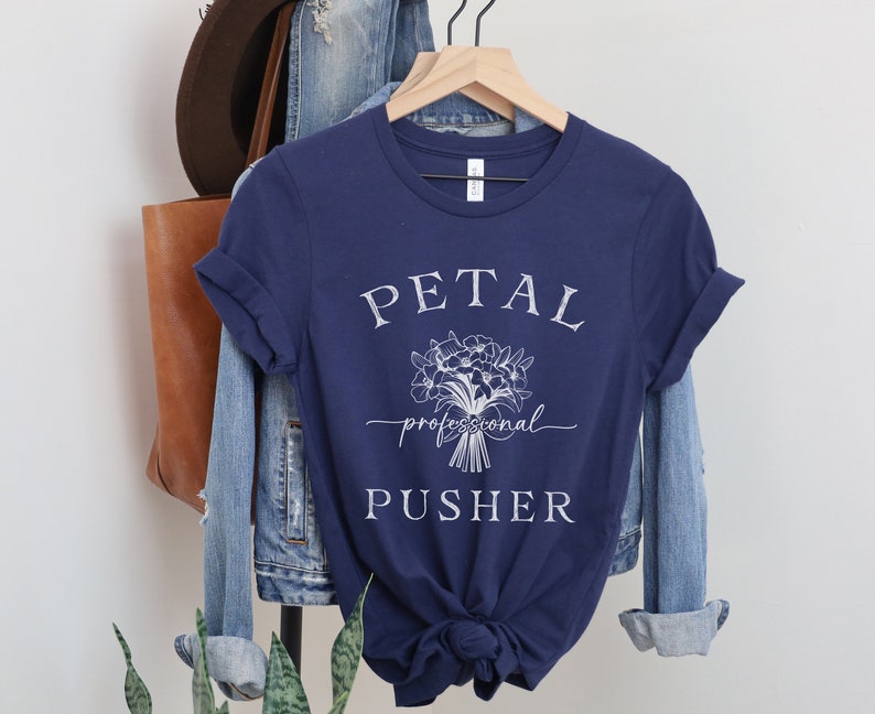 May include: A navy blue t-shirt with white text that reads "PETAL professional PUSHER" and a white floral graphic.
