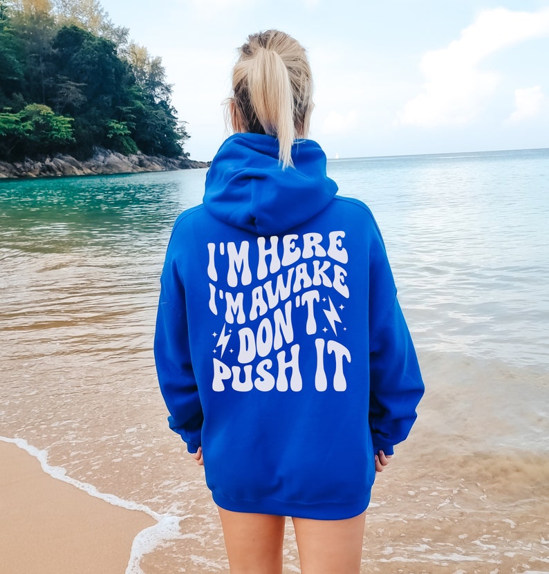 May include: A royal blue hoodie with a white graphic that reads "I'm here I'm awake Don't push it" in a retro font.