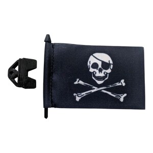 May include: A black pirate flag with a white skull and crossbones design. The flag is rectangular and attached to a black pole. A black plastic clip is next to the flag.