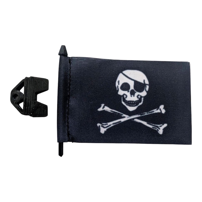 May include: A black pirate flag with a white skull and crossbones design. The flag is rectangular and attached to a black pole. A black plastic clip is next to the flag.