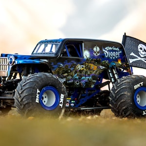 May include: A black and blue monster truck with large tyres and a skull and crossbones flag. The truck has the words "Grave Digger" on the side and a skull graphic. The tyres have blue rims and the word "BKT" on the sidewalls.
