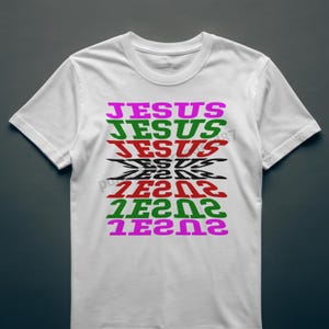 Puede incluir: Camiseta blanca con la palabra "JESUS" en un diseño apilado y colorido. La palabra se repite en varios colores, incluyendo rosa, verde, rojo y negro, creando un gráfico llamativo.