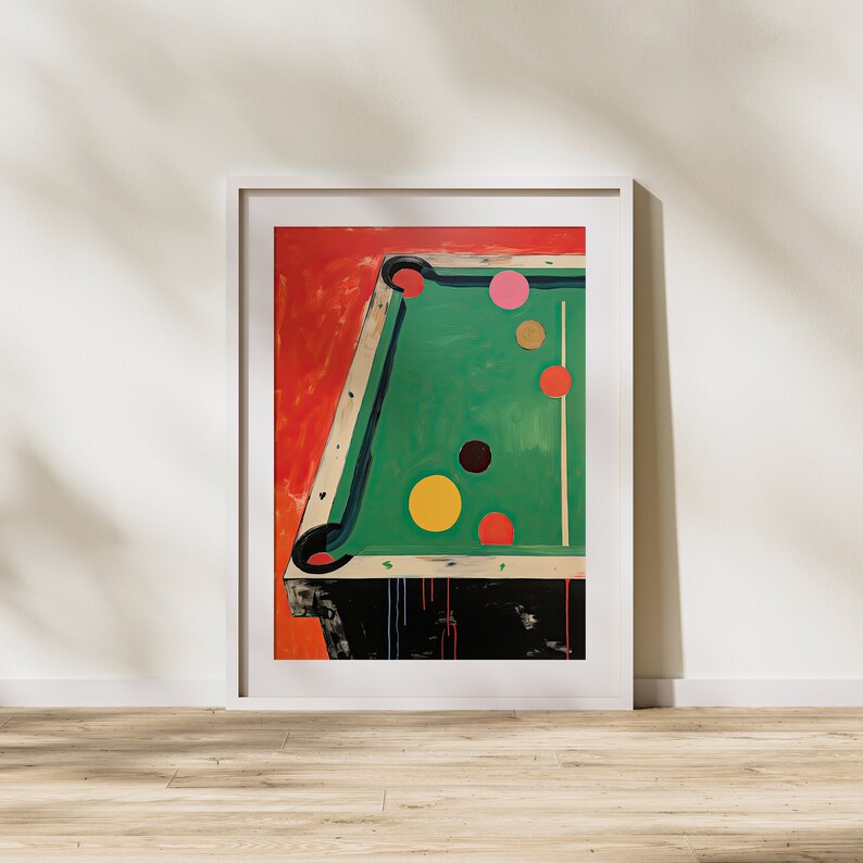 May include: A framed painting depicting a green pool table with colourful balls. The table is set against a red background. The balls are arranged in a line, with the cue ball at the front.