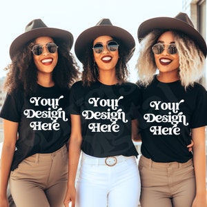 May include: Three people wearing black t-shirts with the text "Your Design Here" in white. They are all wearing black hats and sunglasses.
