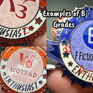 Op de afbeelding: Close-up van drie kleurrijke emaille pins. De pins bevatten tekst zoals "Enthusiast" en "WOTPAD". De pins zijn cirkelvormig met ster- en lintontwerpen. De tekst "Examples of B Grades" is ook zichtbaar.