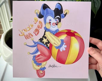May include: A whimsical illustration of a jester holding a red and yellow striped ball. The jester is wearing a blue and black hat with bells, a red and yellow star patterned shirt, and red pants with blue and yellow trim. The background is pink and the text "Just a lil' guy" is written in a playful font.