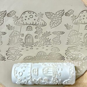 May include: A white rolling pin with a mushroom house and mushroom design. The rolling pin is used to create an imprint on clay.