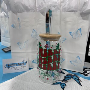 Lata de cerveza navideña, árboles de Navidad, luces navideñas, vaso de café navideño, café helado de verano