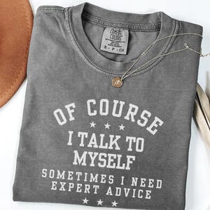 May include: Gray t-shirt with white text that reads "Of course I talk to myself. Sometimes I need expert advice."