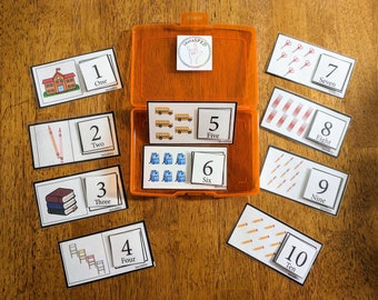 May include: A set of ten colourful flashcards with numbers 1 to 10, each with a corresponding image. The images include a schoolhouse, pencils, books, stairs, school buses, backpacks, scissors, crayons, and pencils. The cards are labelled with the number and the word for the number.