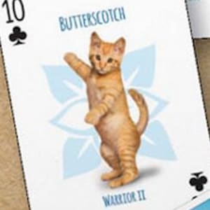 May include: A playing card with a 10 of clubs symbol. The card features a cartoon illustration of an orange tabby kitten standing on its hind legs. The card also has the text "Butterscotch" and "Warrior II" printed on it.