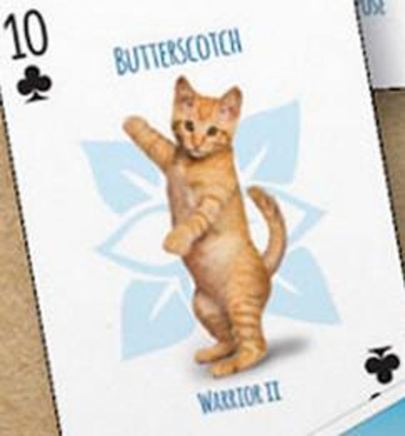 May include: A playing card with a 10 of clubs symbol. The card features a cartoon illustration of an orange tabby kitten standing on its hind legs. The card also has the text "Butterscotch" and "Warrior II" printed on it.