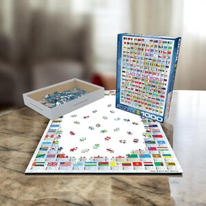 Peut inclure: Un puzzle de 1000 pièces représentant les drapeaux du monde. La boîte du puzzle est bleue avec du texte blanc et une image du puzzle terminé. Le puzzle est fabriqué par Eurographics.